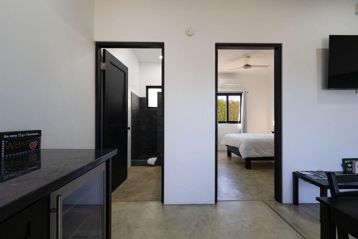 Una habitación de hotel moderna con una cama, un escritorio y un televisor.