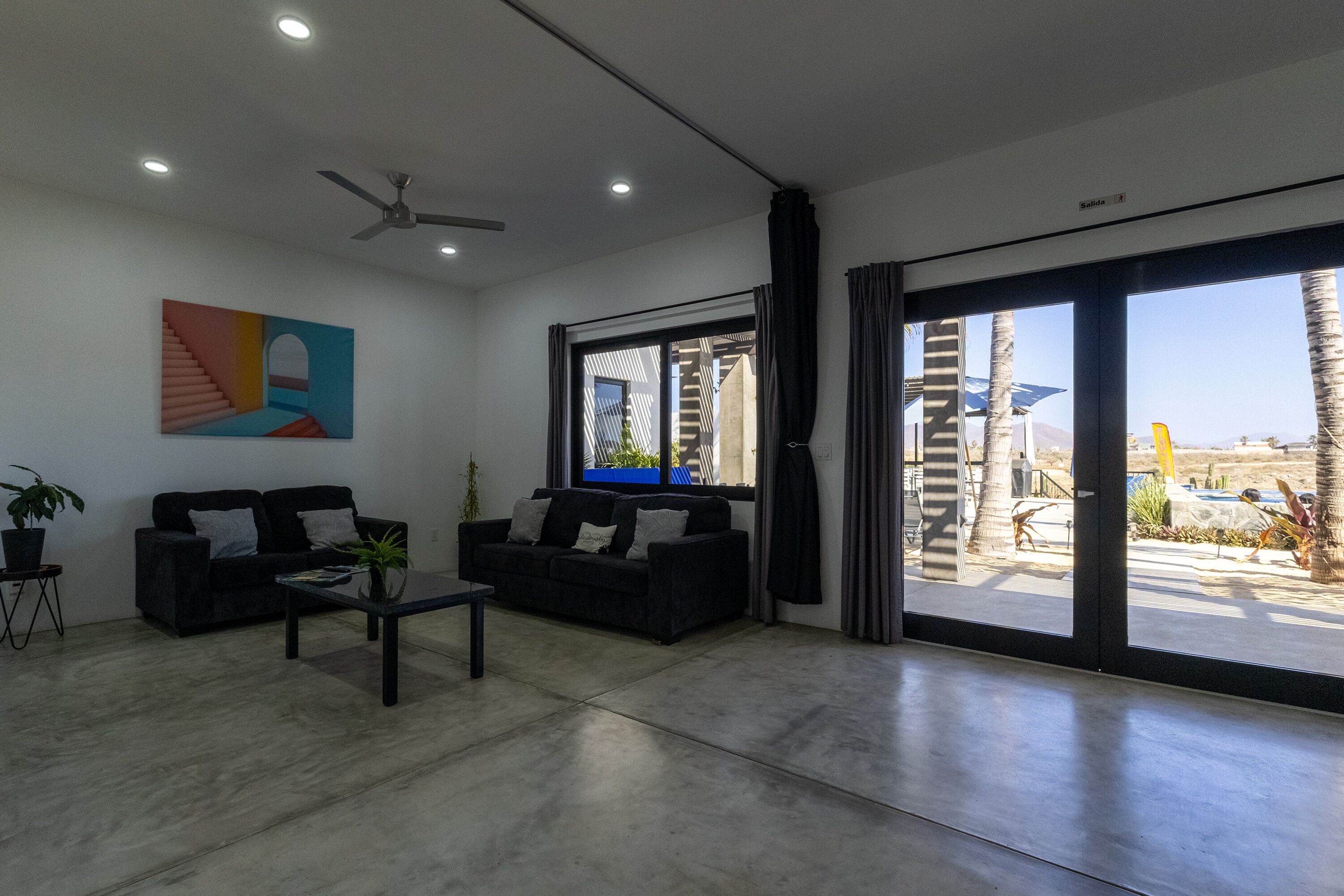 Una sala de estar moderna con sofá, mesa de centro y una obra de arte en la pared.