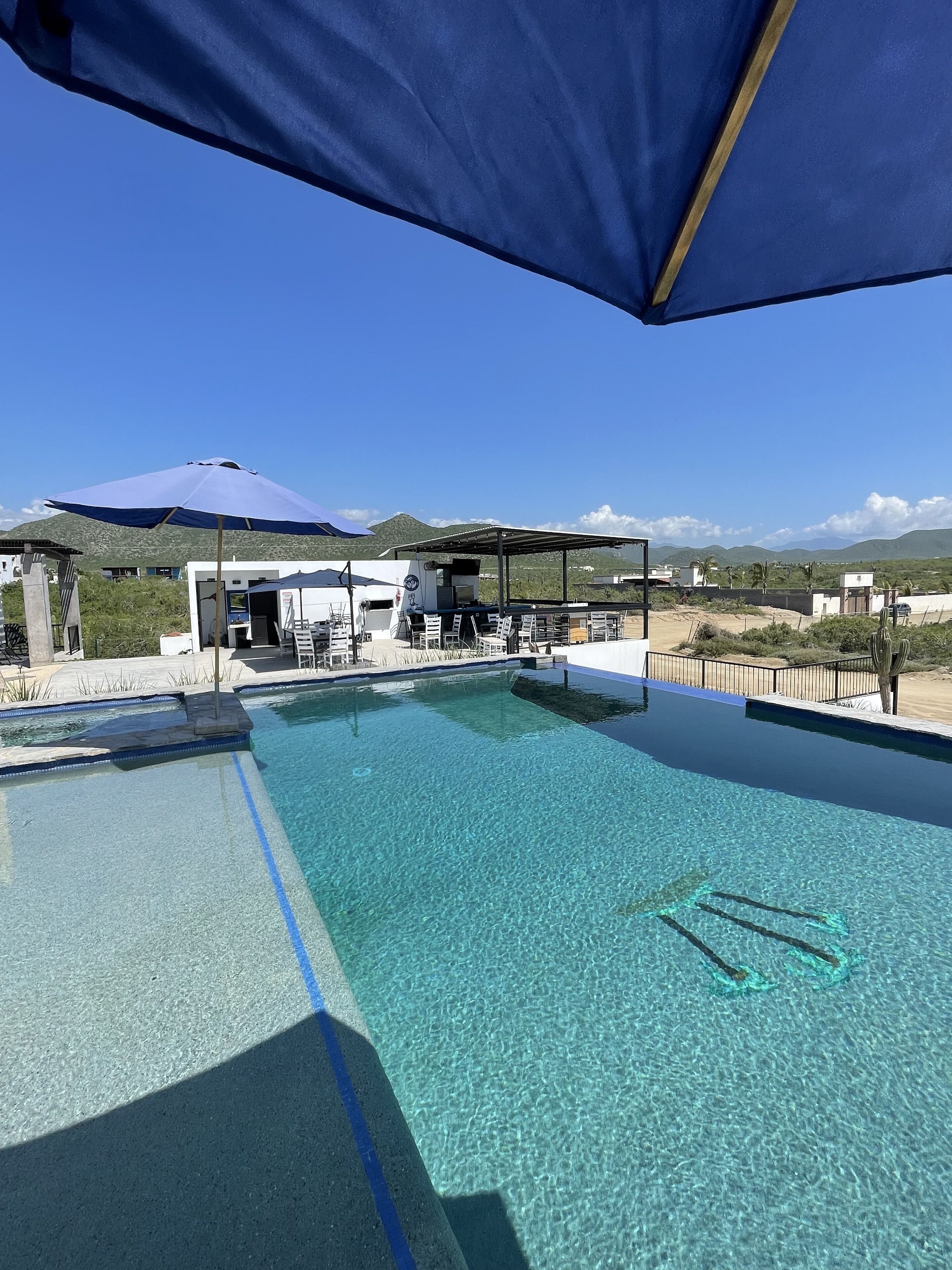 Alberca al aire libre, sombrillas en la alberca y camastros 