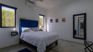 Un dormitorio con cama, ventilador de techo, ventana y espejo.