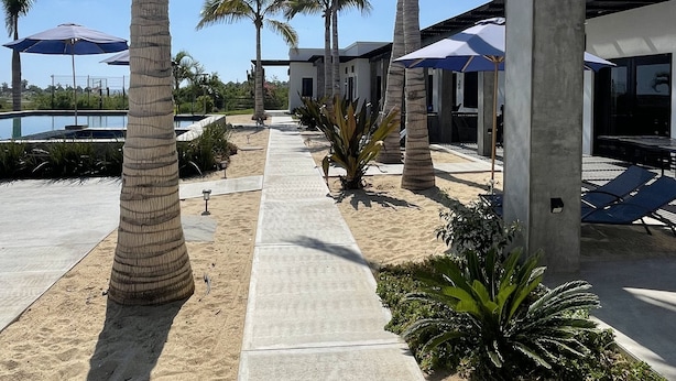 Um resort com palmeiras, área de estar ao ar livre e piscina.