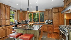 Una cocina amplia con armarios de madera, una isla grande y electrodomésticos de acero inoxidable.
