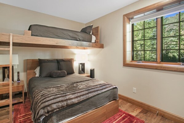 A bunk bed room with a window, a bedside table, and a lamp. - On Vail Bus Route! Hot Tub, Fire Pit, Sauna! (Vail)