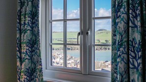 A window with a view of a coastal town and a body of water. - Waders (Salcombe)