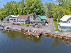 A waterfront property with a dock, multiple buildings, and a grassy area.
