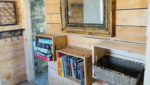 Un interior de madera con un espejo, estanterías y una cesta.