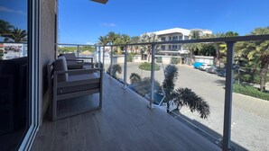 Un balcon donnant sur un parking et des immeubles.
