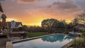 A rectangular pool with a stone border, surrounded by a wooden deck and a grassy area. - Wine Country Gateway w/ Views Btwn Napa & SF (Vallejo)