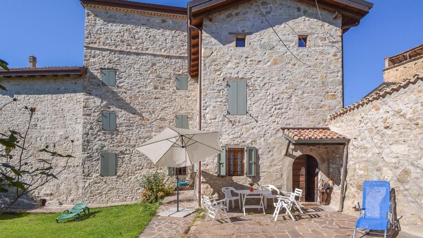 A stone building with a patio area featuring outdoor furniture and a table. - Pet friendly home in Monchio delle Olle (Monchio delle Olle)