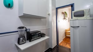 A compact kitchen with a microwave, toaster, and blender on a white countertop. - Studio in Copacabana Ideal for the Family Jc509 (Rio de Janeiro)