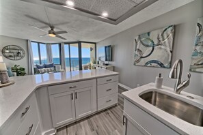 Una cucina moderna con una grande isola, un lavello integrato e una ventola a soffitto.