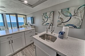 Una cucina moderna con una grande isola, un lavello in acciaio inossidabile e opere d'arte alle pareti.