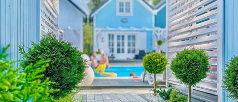 Una piscina al aire libre, sillones reclinables de piscina