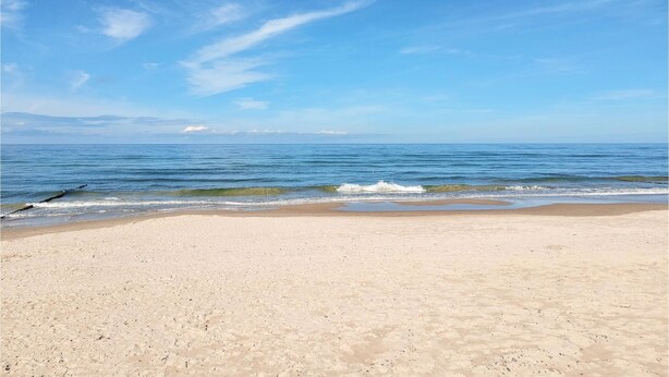 A wide sandy beach with gentle waves and a clear blue sky. - Nice home in Slowienkowo with WiFi (Slowienkowo)