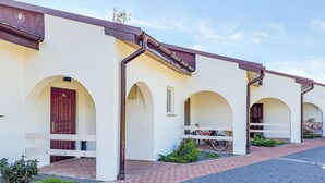 A row of white buildings with arched doorways and a bicycle parked in front. - Nice home in Slowienkowo with WiFi (Slowienkowo)