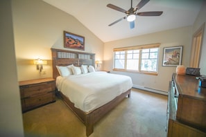 A bedroom with a wooden bed, a ceiling fan, a nightstand, a dresser, and a window with blinds. - Starfire 1994 (Keystone)