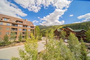 A multi-story hotel with balconies, surrounded by trees and mountains. - Expedition Station 8593 (Keystone)