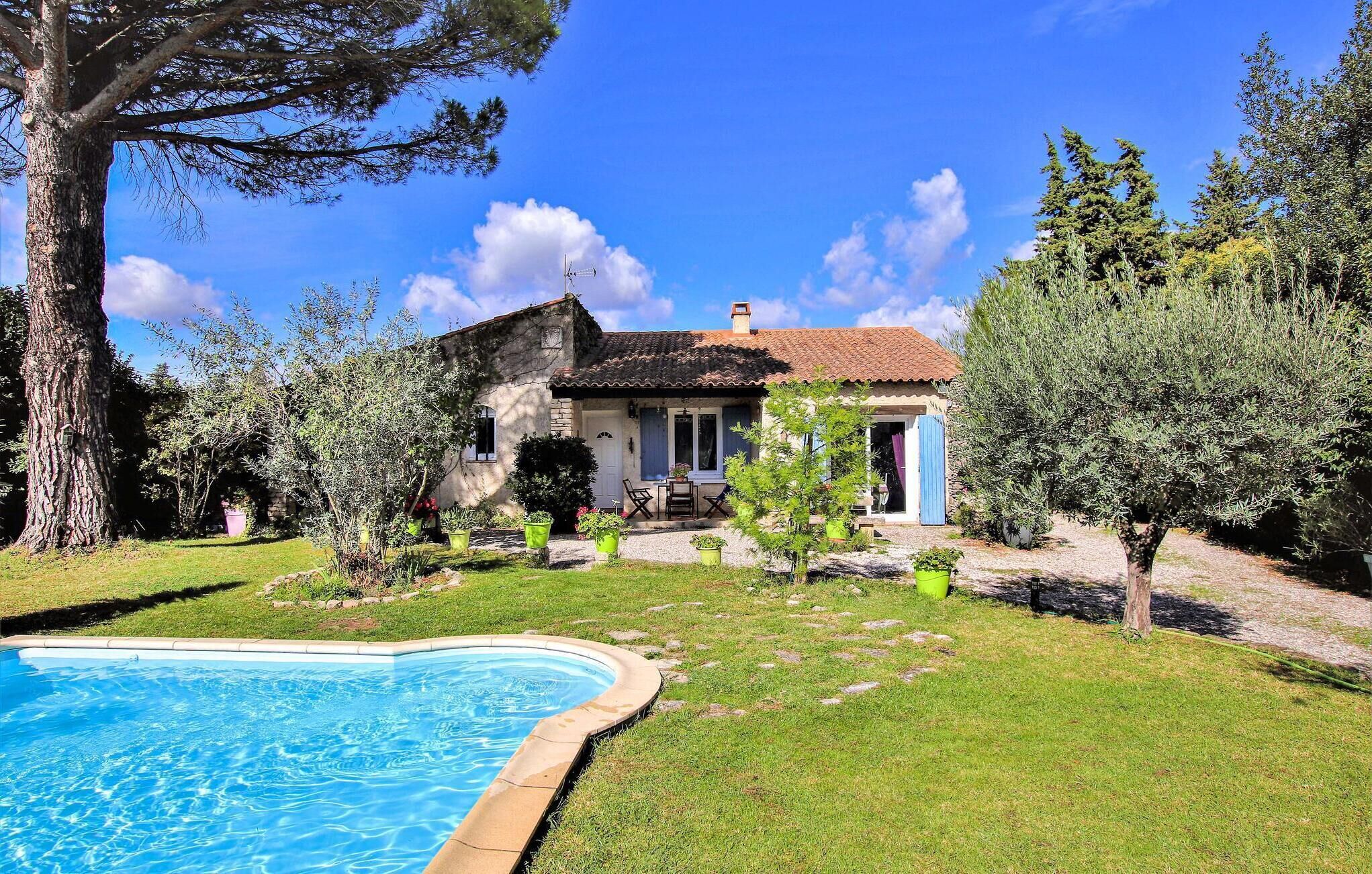 Una casa amb piscina, envoltada de vegetació i arbres.