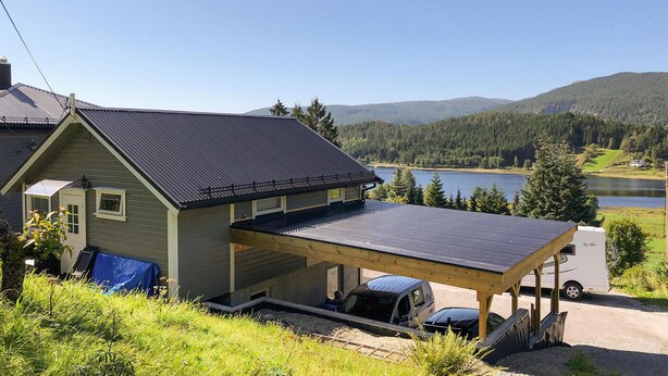 A two-story house with a large deck and a covered carport. - 1 bedroom stunning home in Tonstad (Tonstad)