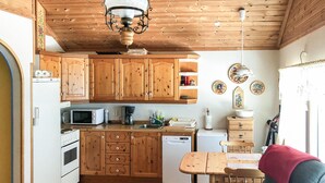 A kitchen with wooden cabinets, a microwave, a coffee maker, and a sink. - 1 bedroom stunning home in Tonstad (Tonstad)
