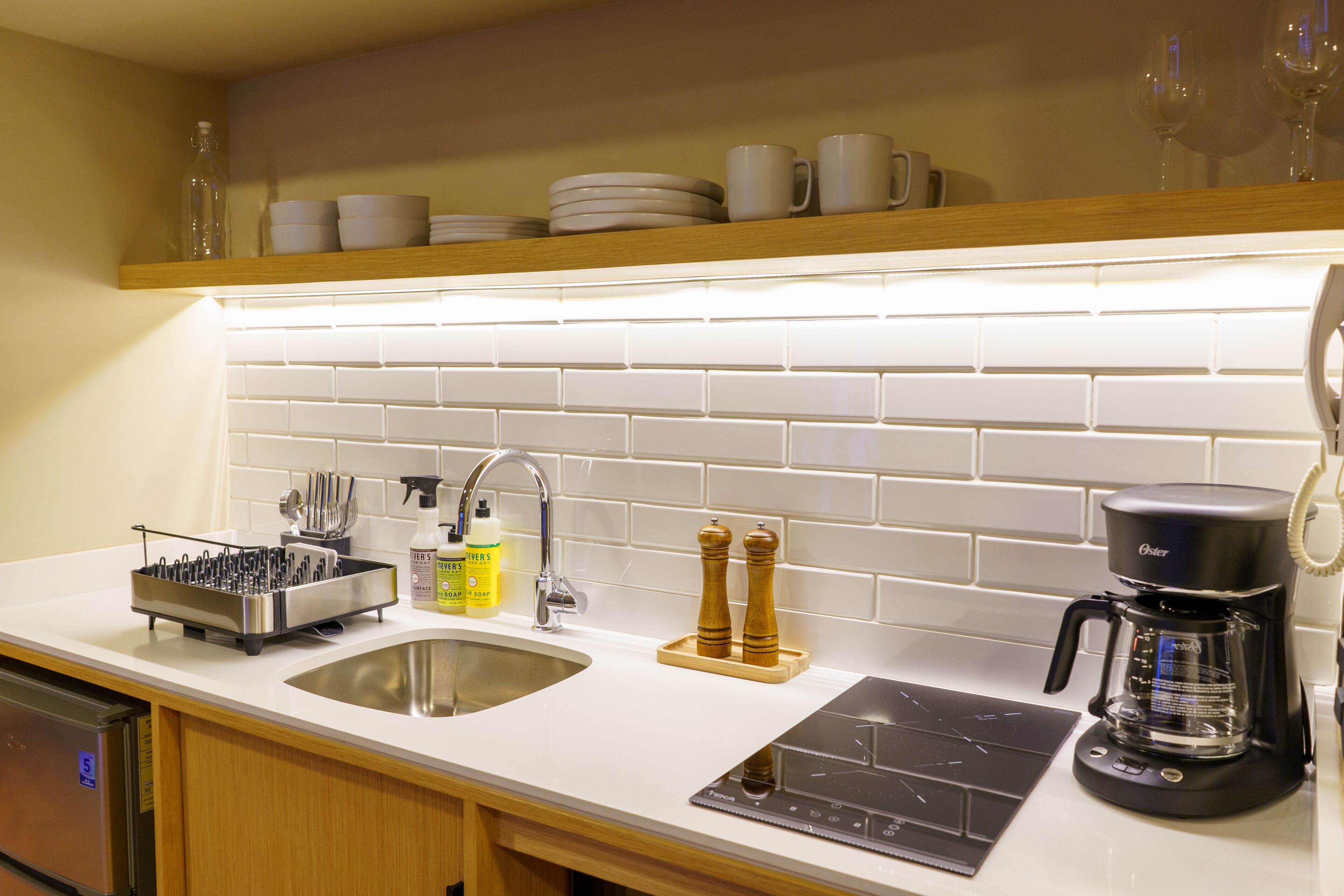 A modern kitchen with a stainless steel sink, a coffee maker, and a knife block.