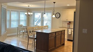 A modern kitchen with wooden cabinets, a central island, and pendant lighting. - CENTER OF OCEAN CITY - Walk to Beach/Boards/Downtown (Ocean City)