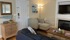 A living room with a sofa, a small table with a lamp, a fireplace, and a television. - CENTER OF OCEAN CITY - Walk to Beach/Boards/Downtown (Ocean City)