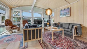 Un amplio salón con un ventanal grande, chimenea, sofá y mesa de centro.