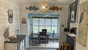 Ett kök med matplats, med ett stort fönster, en takfläkt och en dekorativ lampa.