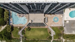 A high-rise building with a rooftop pool, a circular pool, and a landscaped area with pathways. - Bright Oceanfront 1br,King,Pool,Sm Dogs,W54 (Myrtle Beach)