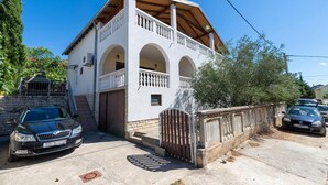 Ein zweistöckiges Gebäude mit Balkon, Garage und einem verschlossenen Eingang.