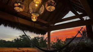 A hammock, a sofa, and a ceiling with hanging lights.