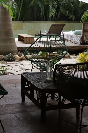 A patio area with a table, chairs, and a bench. - Hotel Gallo de Mar (Puerto Escondido)