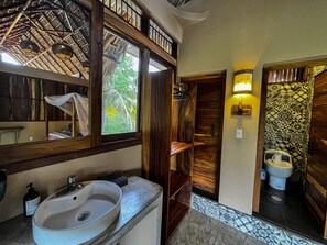 A bathroom with a wooden vanity, a sink, and a toilet. - Hotel Gallo de Mar (Puerto Escondido)