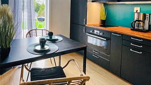 A modern kitchen with dark cabinetry, a wooden countertop, and a coffee machine. - Amazing home in Ronneby with WiFi (Ronneby)