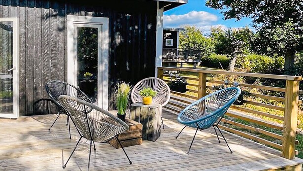 A wooden deck with two wicker chairs and a small table with a plant. - Amazing home in Ronneby with WiFi (Ronneby)