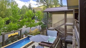 A backyard with a swimming pool, hot tub, and outdoor seating.