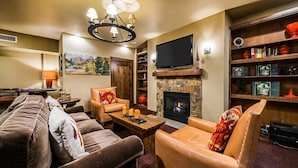 A living room with a fireplace, a television, and a bookshelf.