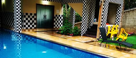 An indoor swimming pool with checkered patterns on the walls and a checkered tablecloth.