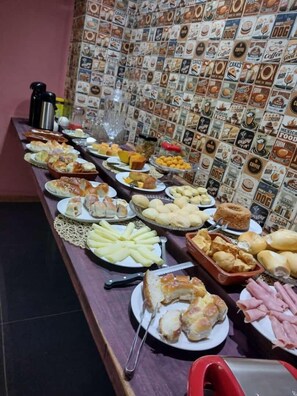Indulge in a spread of sliced meats, pastries, and desserts at this buffet.