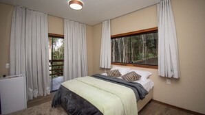 A bedroom with a bed, curtains, a window, and a radiator. - Pousada Evolução engenho (Nova Lima)