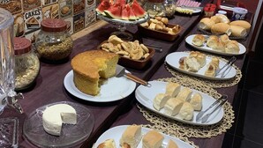 A buffet table with various food items and a wall decorated with food-related posters. - Pousada Evolução engenho (Nova Lima)