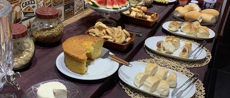 A buffet table with various food items and a wall decorated with food-related posters.