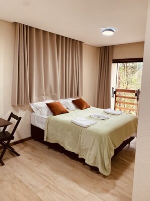 Relax in a serene space with a comfortable bed, a cozy reading nook, and a view of lush greenery.