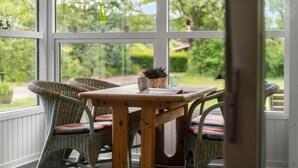 A wooden table with chairs in a room with large windows. - Nice home in Hemmet with WiFi (Hemmet)