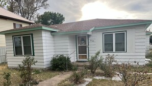A single-story house with a green door, a small porch, and a number '602' on the door. - Cozy home with easy access to the main highway thru town, but in quiet area.  (Laverne)