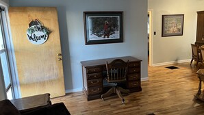 A room with a wooden desk, a chair, a welcome sign, and two framed pictures on the wall. - Cozy home with easy access to the main highway thru town, but in quiet area.  (Laverne)