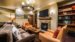 Ein Wohnzimmer mit Kamin, Fernseher und Bücherregal.