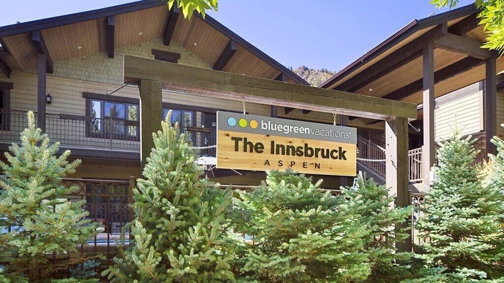 A wooden sign for The Innsbruck Aspen with a logo for Bluegreen Vacations.