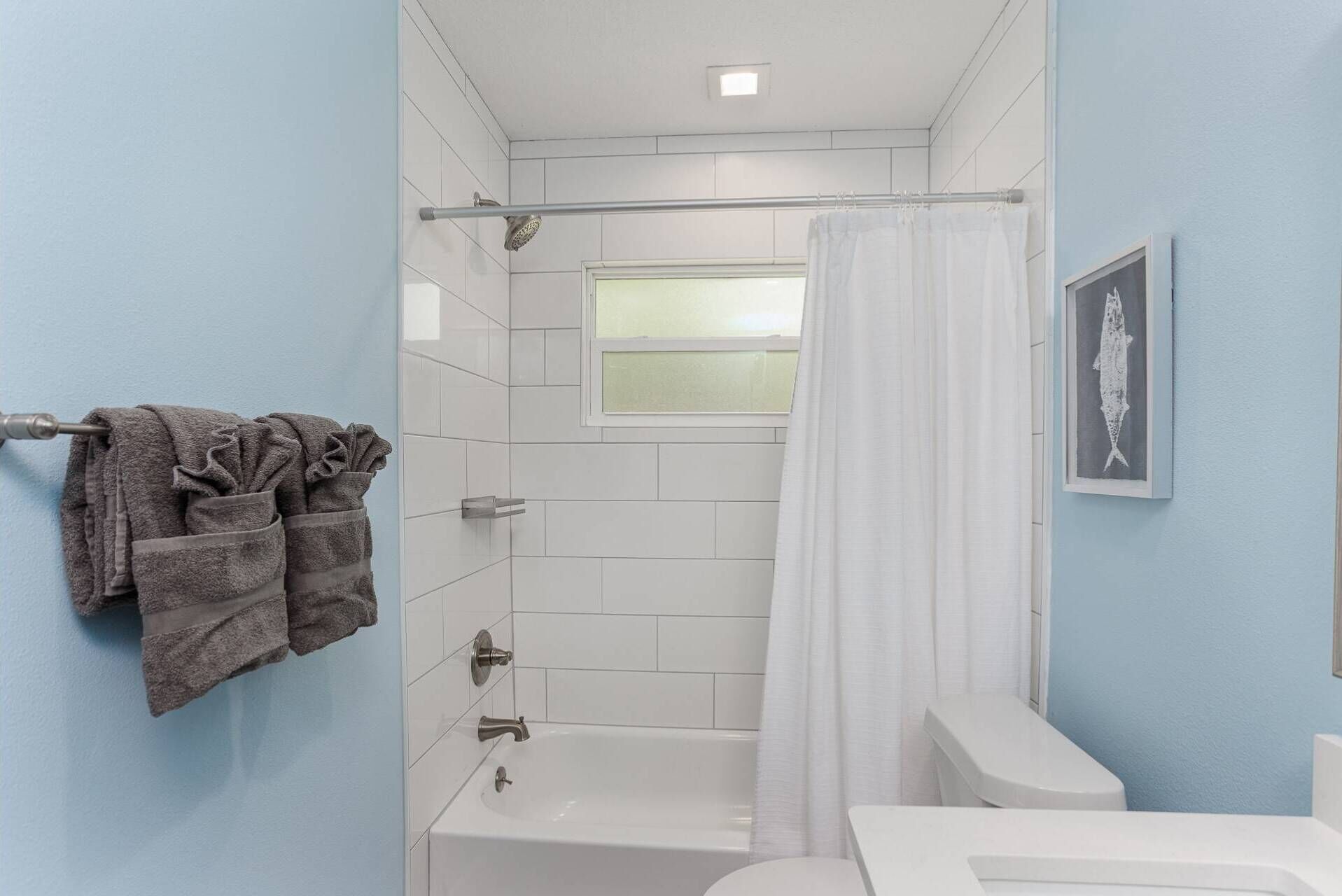Un baño con bañera, cortina de ducha y un perchero con toallas.